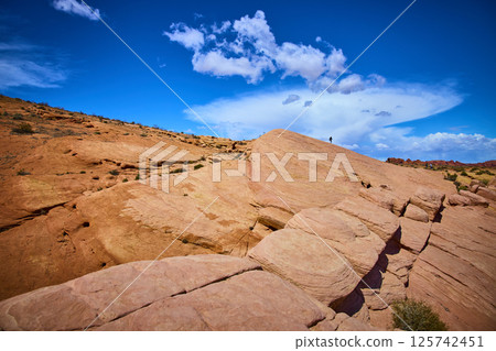 Majestic Sandstone Formations with Lone Explorer Low Angle View Majestic Sandstone Formations with Lone Explorer Low Angle View 125742451