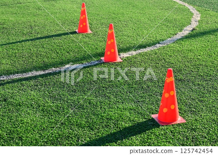 artificial green grass soccer field with orange training cones artificial green grass soccer field with orange training cones 125742454