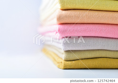 stack of colourful cotton clothes, pile of clothing on white background stack of colourful cotton clothes, pile of clothing on white background 125742464