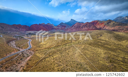 Aerial of Red Rock Canyon's Rugged Peaks and Desert Roadway 125742602