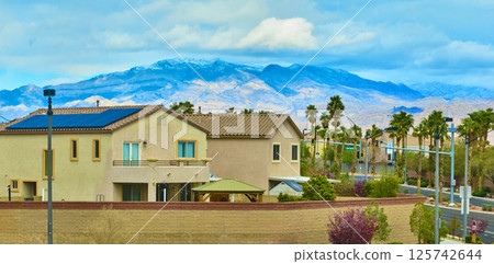 Aerial of Solar-Powered Suburban Home with Mountain Backdrop 125742644
