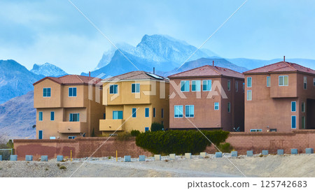 Modern Desert Homes with Mountain Views and Overcast Sky Perspective Modern Desert Homes with Mountain Views and Overcast Sky Perspective 125742683