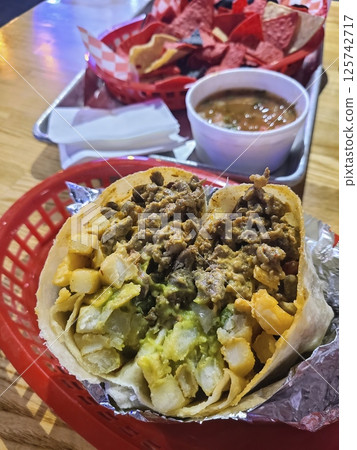 Hearty Burrito with Fries and Guacamole Closeup at Eye Level 125742717