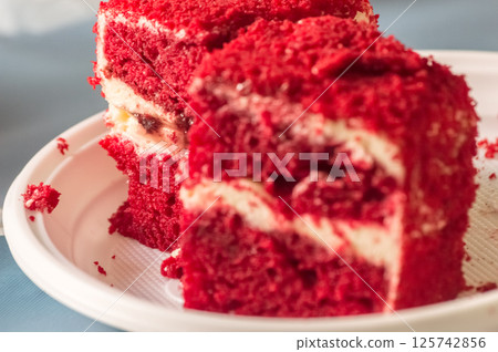 Close-up of a piece of red velvet cake with frosting 125742856