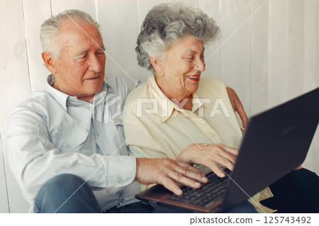 Grandparents at home. Old people use the laptop. Senior in a blue shirt. 125743492