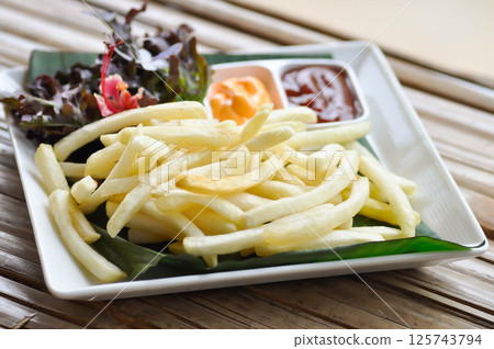 French fries or fried potato , fries with keychup and cheese dip 125743794