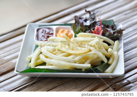 French fries or fried potato , fries with keychup and cheese dip 125743795
