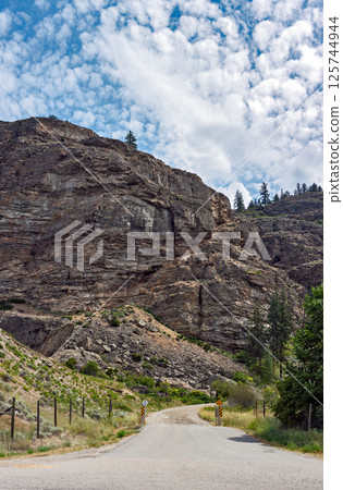Gated gravel road leading to the mounain area in Canada. Vertical panorama Gated gravel road leading to the mounain area in Canada. Vertical panorama 125744944