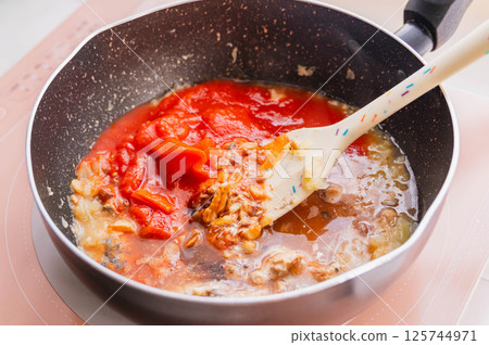 將整顆番茄加入煮熟的洋蔥和鯖魚中，然後慢燉。 125744971