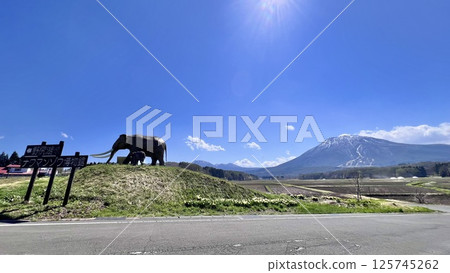 The statue of the mother and child Naumann's elephant at Lake Nojiri and the remaining snow on Mt. Kurohime from National Route 18 125745262
