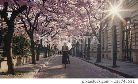 Woman strolling under blooming cherry blossoms 125745581