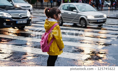 Young student waiting to cross the street on a rainy day Young student waiting to cross the street on a rainy day 125745822