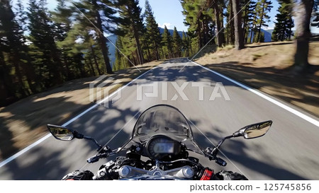Motorcyclist navigating mountain roads through a pine forest 125745856