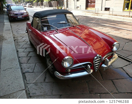 Milan scenery: Cobblestone-paved tramway and red coupe Alfa Romeo 2008.08 125746288