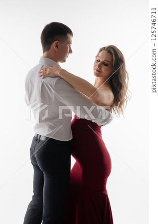 Couple celebrates pregnancy with a romantic dance in a minimalist setting 125746711