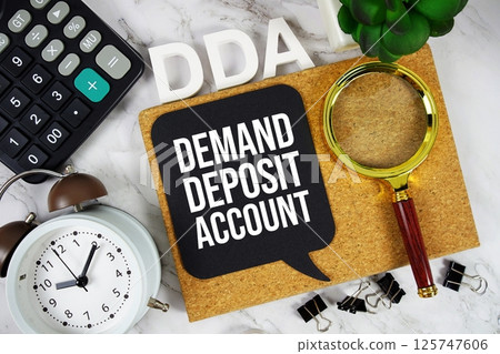 DDA - Demand Deposit Account acronym with calculator, alarm clock and magnifying glass, Business and Financial concept background DDA - Demand Deposit Account acronym with calculator, alarm clock and magnifying glass, Business and Financial concept background 125747606