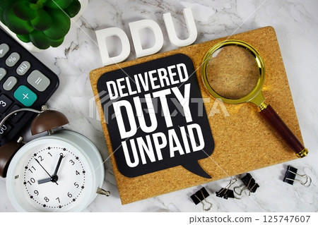 DDU - Delivered Duty Unpaid acronym with calculator, alarm clock and magnifying glass, Business concept background DDU - Delivered Duty Unpaid acronym with calculator, alarm clock and magnifying glass, Business concept background 125747607