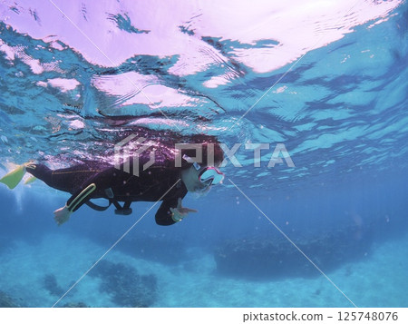 A woman enjoying snorkeling in the blue waters of Ishigaki Island 125748076