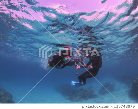 A family enjoying snorkeling in the blue waters of Ishigaki Island 125748079