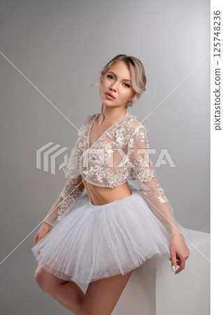Elegant woman showcasing beauty in lingerie while dancing in studio setting Elegant woman showcasing beauty in lingerie while dancing in studio setting 125748236