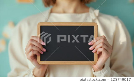 A woman presents a blackboard, signifying strength and advancement on International Women's Day A woman presents a blackboard, signifying strength and advancement on International Women's Day 125749017