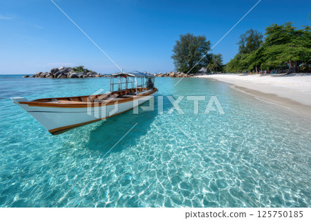 Wooden boat floats on clear turquoise water near pristine white sandy beach, surrounded by lush green trees under bright blue sky. tranquil scene evokes sense of relaxation 125750185