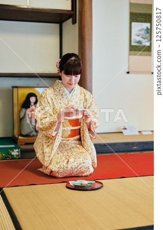 A woman in her twenties wearing a kimono experiencing a tea ceremony 125750817