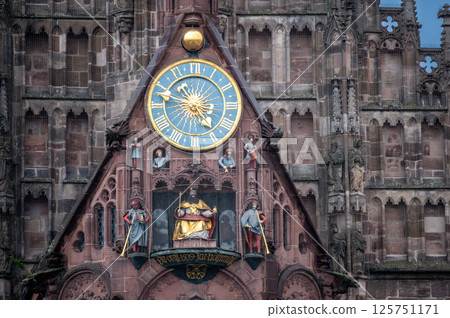 Nuremberg, Germany, August 2, 2023. Detail of the facade of the Church of Our Lady, in the market square. Under the large golden clock several statues. 125751171