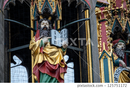 Nuremberg, Germany, August 2, 2023. Detail of one of the many statues that characterize the golden fountain in the market square. Travel destinations and tourist attractions. Nuremberg, Germany, August 2, 2023. Detail of one of the many statues that characterize the golden fountain in the market square. Travel destinations and tourist attractions. 125751172