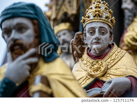 Nuremberg, Germany, August 2, 2023. Detail of one of the many statues that characterize the golden fountain in the market square. Travel destinations and tourist attractions. Nuremberg, Germany, August 2, 2023. Detail of one of the many statues that characterize the golden fountain in the market square. Travel destinations and tourist attractions. 125751174
