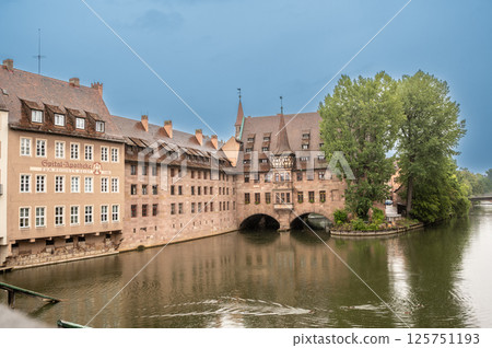 Nuremberg, Germany, August 2, 2023. Shot with a view of the Holy Spirit Hospital on the Pegnitz River, rainy day. Cityscape. Nuremberg, Germany, August 2, 2023. Shot with a view of the Holy Spirit Hospital on the Pegnitz River, rainy day. Cityscape. 125751193