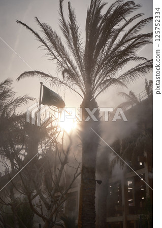 The Saudi Arabian flag and the large roof ring shining in the setting sun 125752334