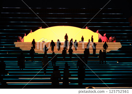 Spain Pavilion at night and silhouettes of people walking Spain Pavilion at night and silhouettes of people walking 125752561