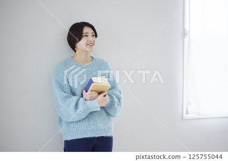 一名大學生拿著一本字典和一本參考書 125755044