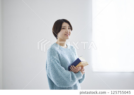 一名大學生拿著一本字典和一本參考書 125755045