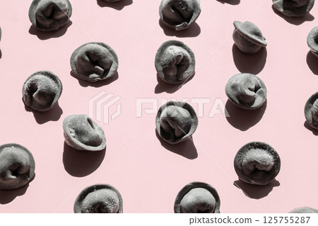Frozen Black Dumplings Lie Scattered on Pink Surface. Quick Meal or Ready to Cook Dinner Ingredient. 125755287