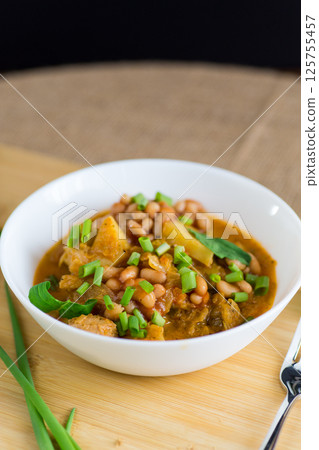 Homemade hearty dish of vegetables, meat and potatoes on a wooden background Homemade hearty dish of vegetables, meat and potatoes on a wooden background 125755457