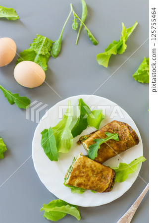 Healthy egg roll with greens on a white plate Healthy egg roll with greens on a white plate 125755464