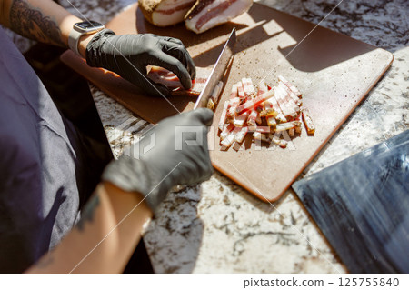 The chef is meticulously preparing fresh, vibrant ingredients on a clean cutting board with care The chef is meticulously preparing fresh, vibrant ingredients on a clean cutting board with care 125755840