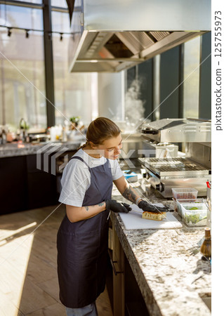 Culinary Arts A Chef Expertly Prepares Fresh Ingredients in a Modern Kitchen Space 125755973