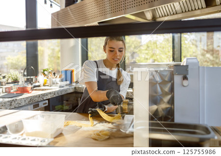 Highly Skilled Culinary Professional Crafting Fresh Pasta in a Contemporary Kitchen Environment Highly Skilled Culinary Professional Crafting Fresh Pasta in a Contemporary Kitchen Environment 125755986