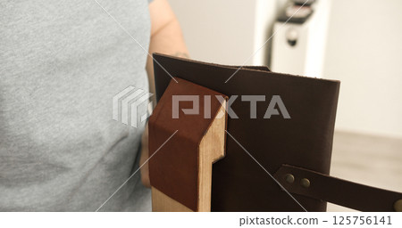 Finished leather accessory shaped on wooden form during crafting 125756141