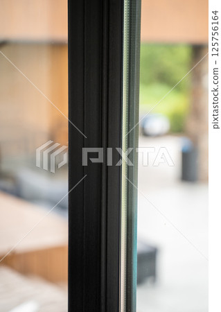 Wide architectural frame shot of black aluminum windows with layered glazing Wide architectural frame shot of black aluminum windows with layered glazing 125756164