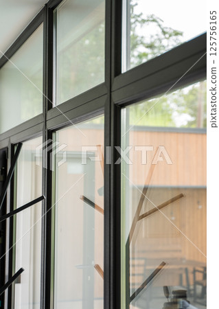 Angled view of modern window frame with clean aluminum junction and outdoor blur 125756165