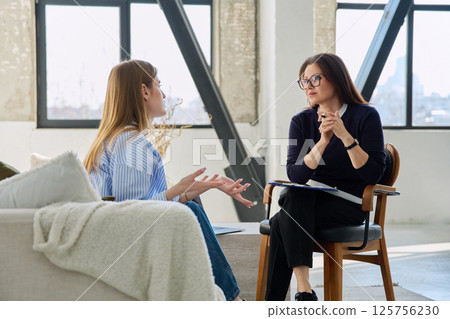 Professional female therapist counselor psychologist working with young woman patient Professional female therapist counselor psychologist working with young woman patient 125756230
