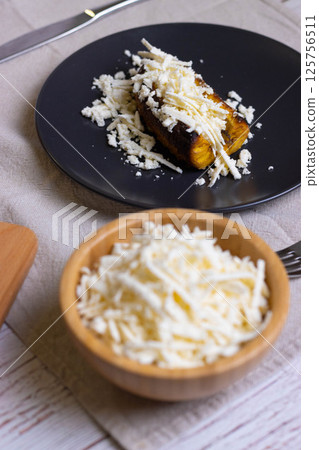 Baked plantains with white cheese 125756511