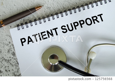 Top view of Patient Support text on white paper notepad with stethoscope on wooden table background. Health and medical concept. 125756568