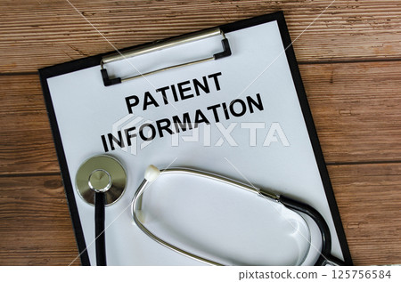 Top view of Patient Information Text on white paper clipboard with stethoscope on wooden table background. Health and medical concept. 125756584