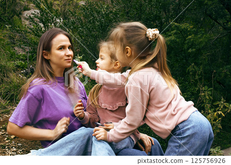 mother with daughter outside doing makeup having fun mother with daughter outside doing makeup having fun 125756926