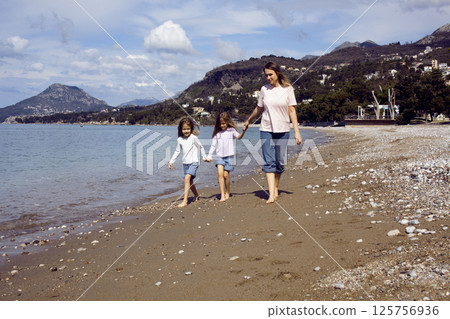 mother with twins daughters on beach lifestyle mother with twins daughters on beach lifestyle 125756936